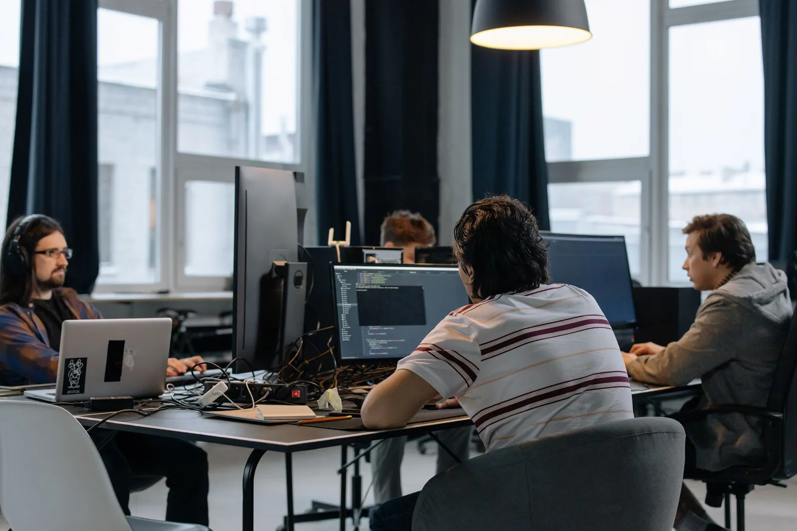 Software engineers collaborating around screens while building a product
